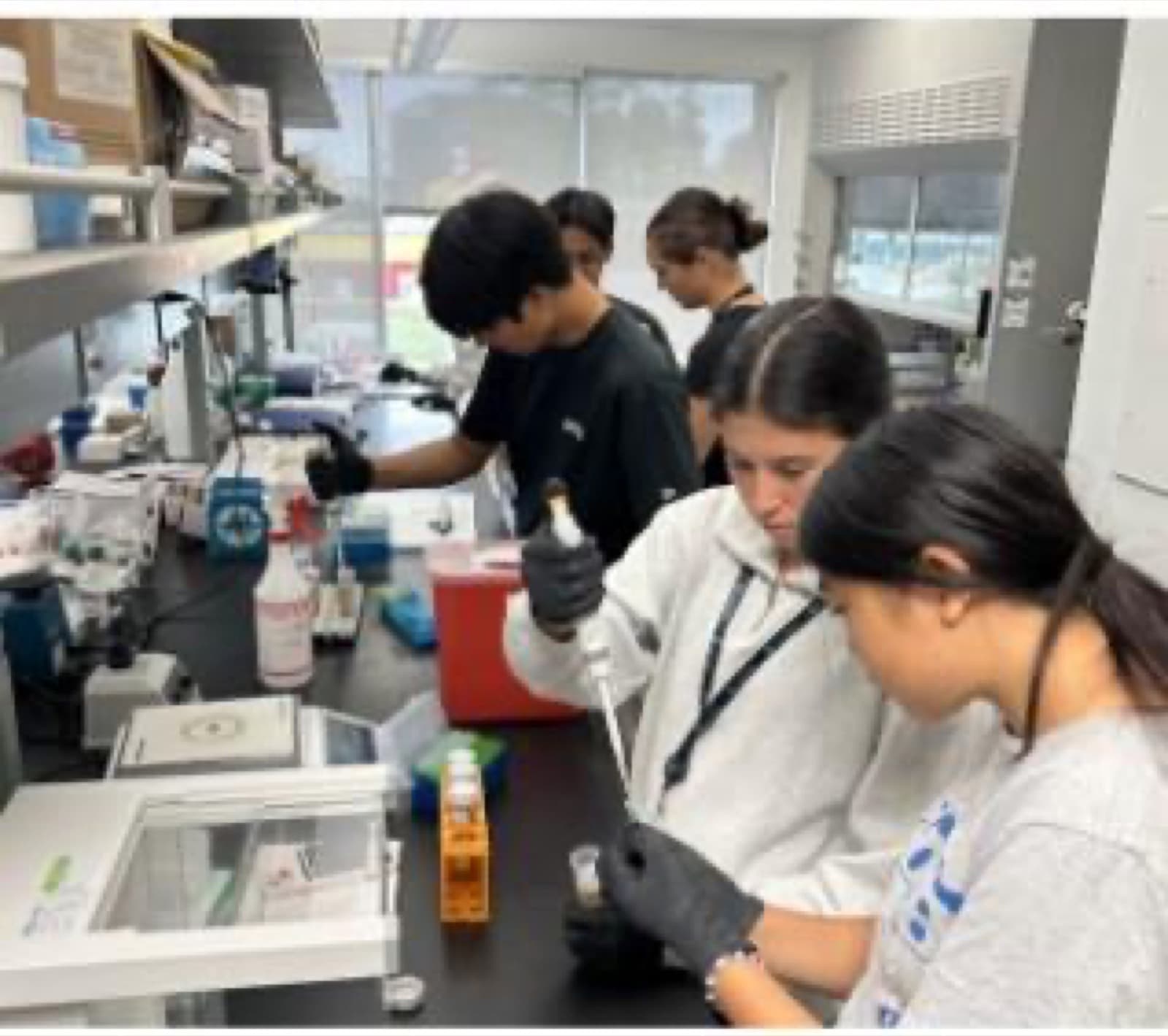 Abby conducting hands-on STEM work with other students in a laboratory
